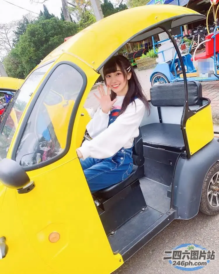 有个女人坐在一辆黄色的车里，举着一只手