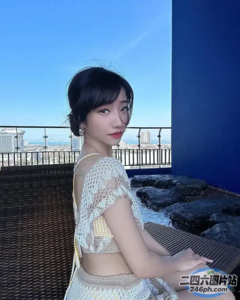 一个女人坐在栏杆附近的长凳上的特写