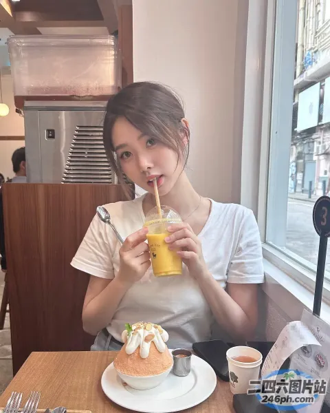 女人坐在有蛋糕的桌子旁喝酒