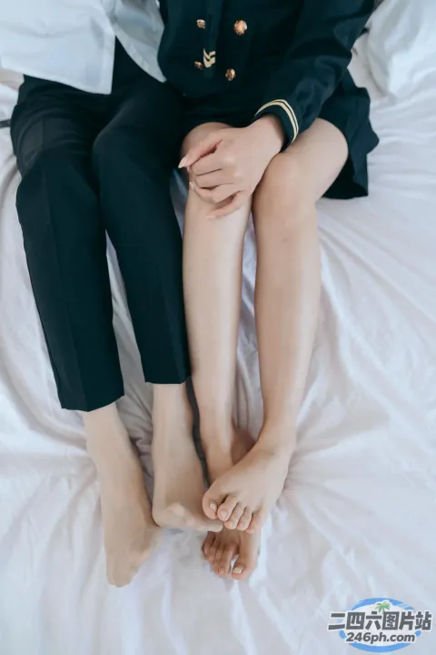 有两个女人坐在床上，双腿交叉