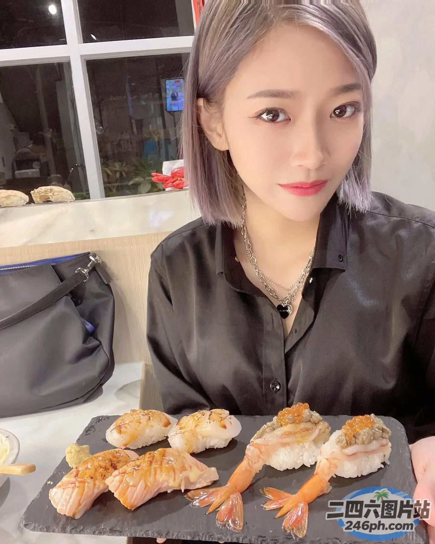 女人拿着一盘虾寿司
