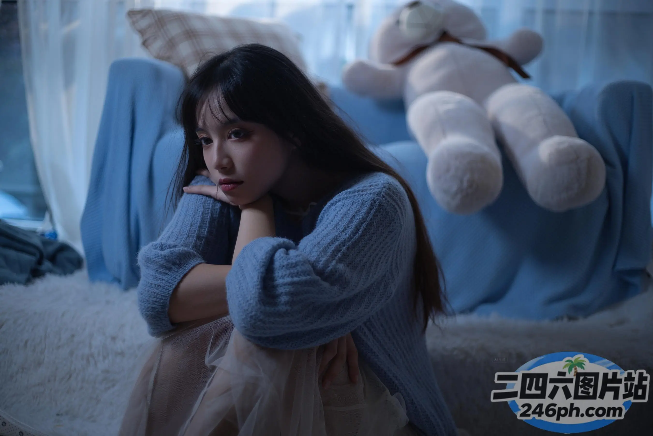 阿拉夫德女人坐在床上，背景是一只泰迪熊
