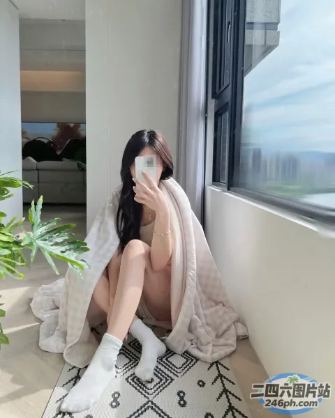 阿拉菲斯女人坐在地板上，头上顶着一条毛巾