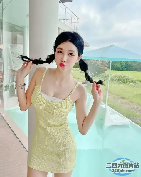 一个穿着黄色连衣裙的女人站在游泳池附近的特写