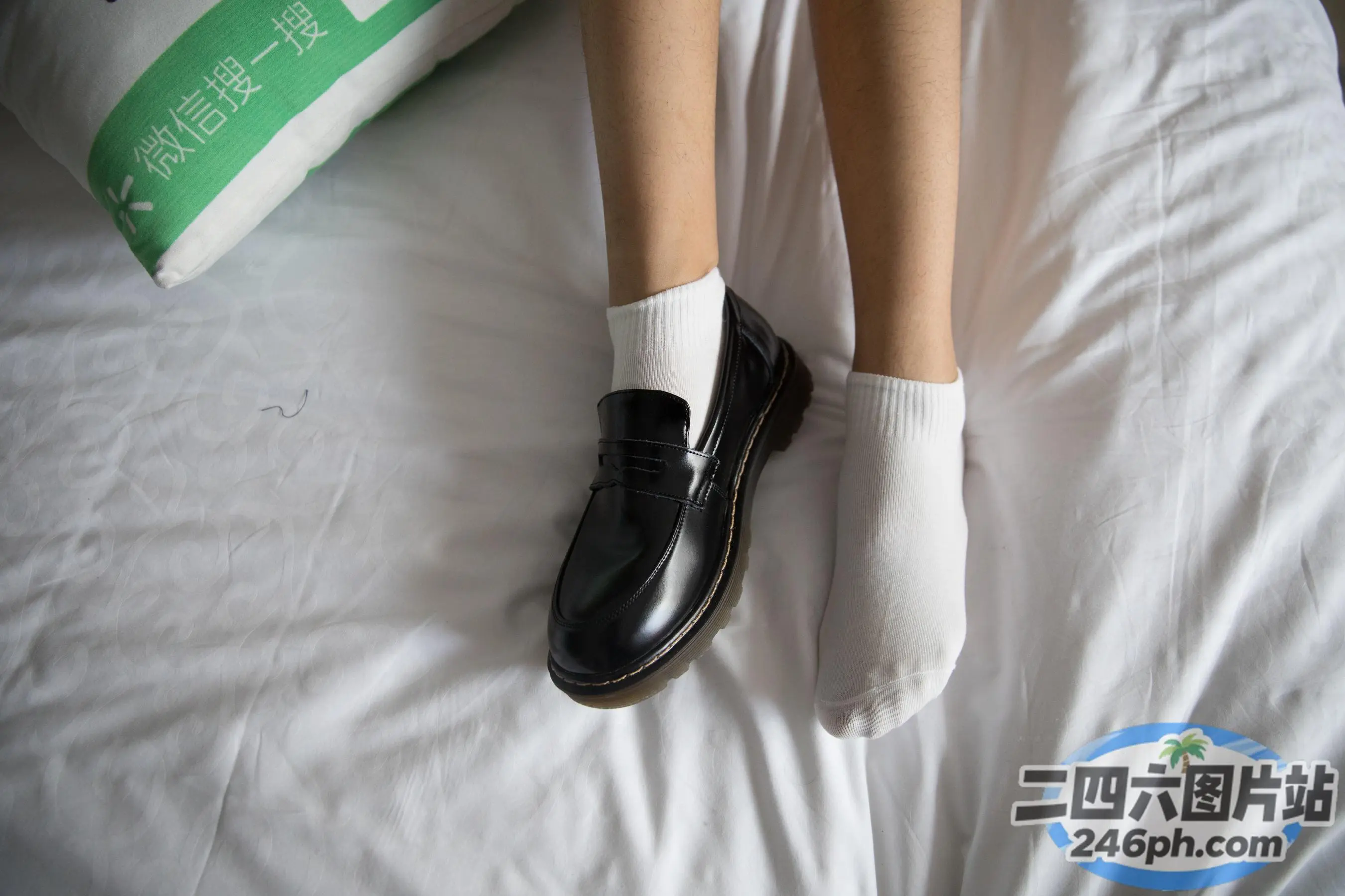 有人穿着黑色鞋子和白色袜子躺在床上