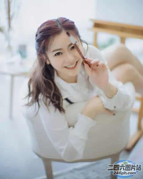 有一位女士坐在椅子上，脸上挂着笑容
