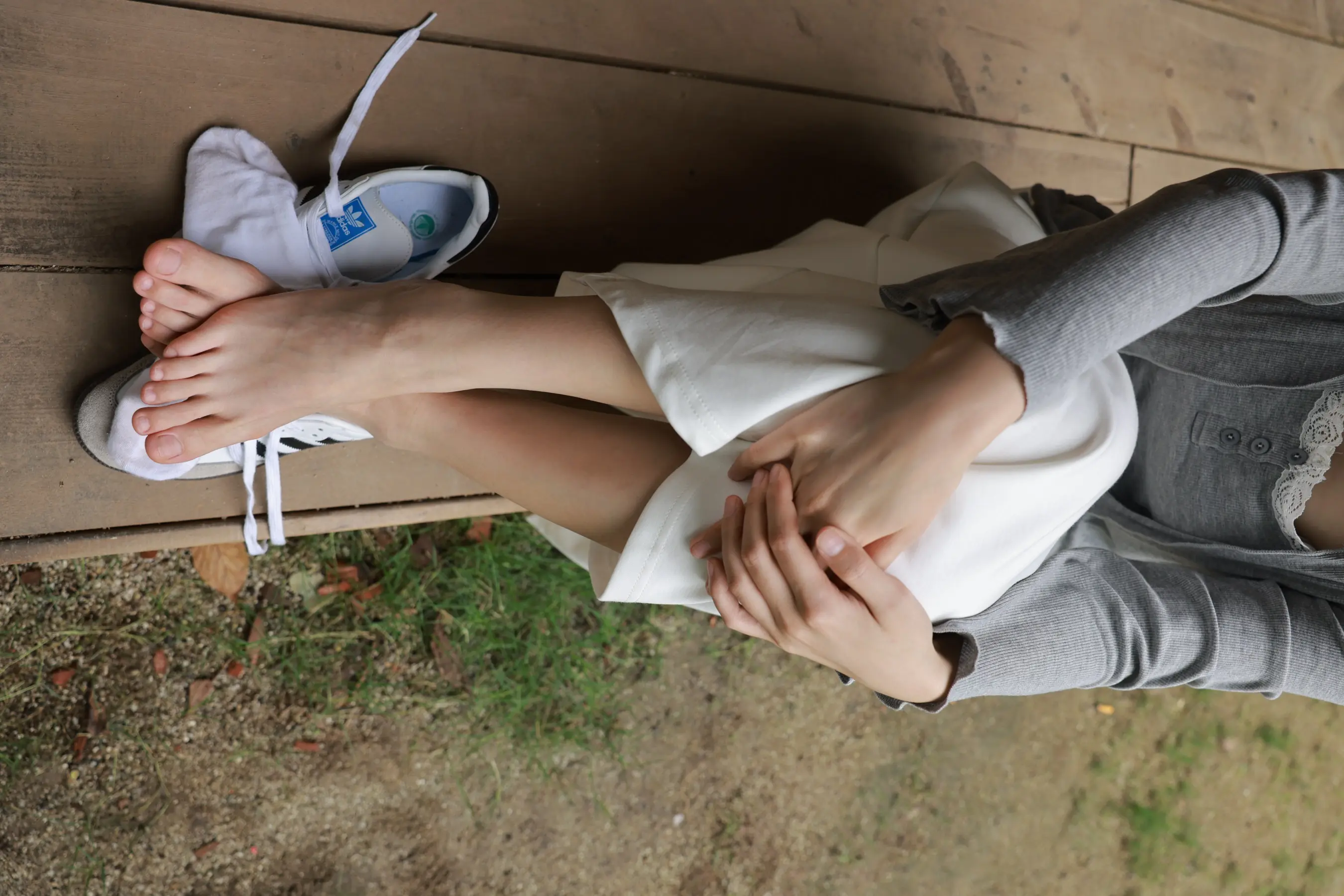 坐在长凳上的阿拉菲德女人，双脚撑着
