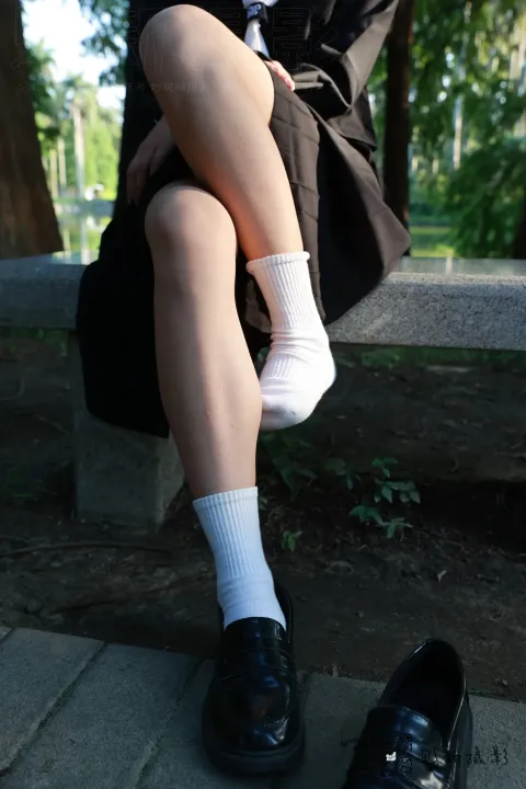 有个女人坐在长凳上，双腿交叉