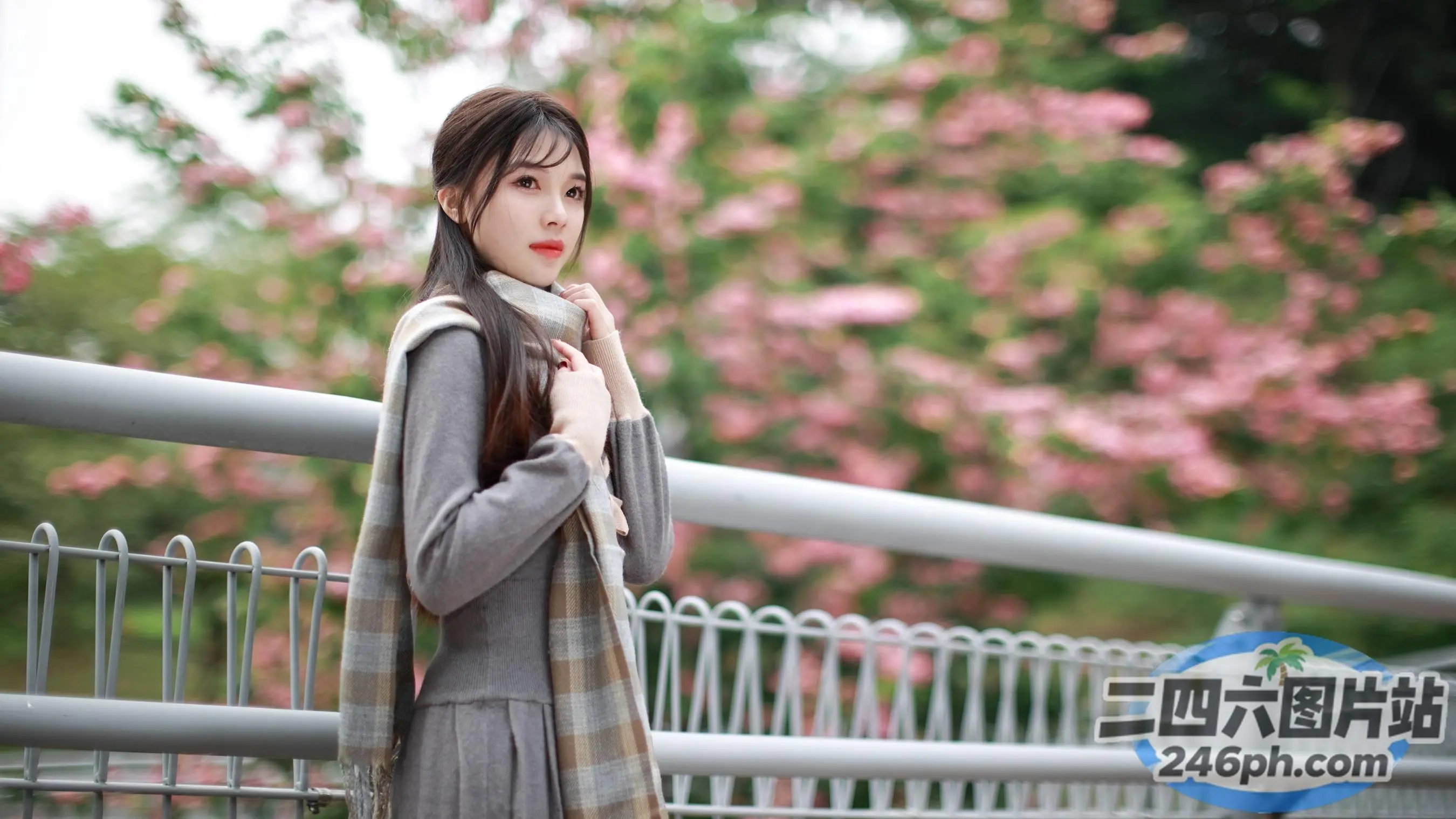 穿着外套和围巾的 araffe 女人站在桥上