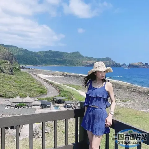 身穿蓝色连衣裙、戴着帽子的 araffe 女子站在阳台上