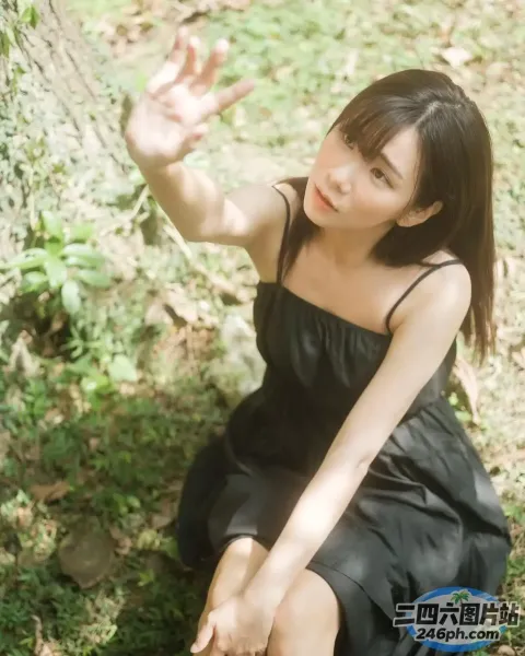坐在地上的黑色连衣裙的 arafed 女人