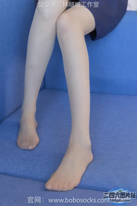 阿拉夫德女人坐在蓝色沙发上，双腿交叉