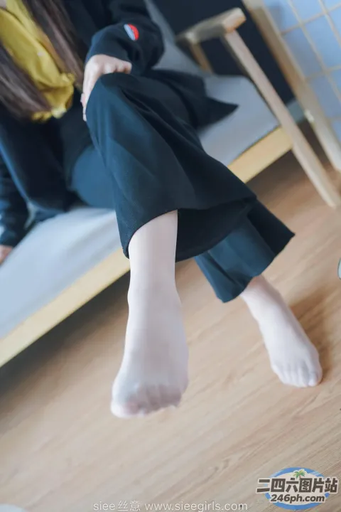 有一个女人坐在床上，双脚抬起