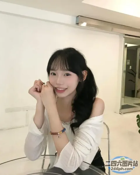 一个女人坐在桌子旁拿着一杯酒的特写镜头