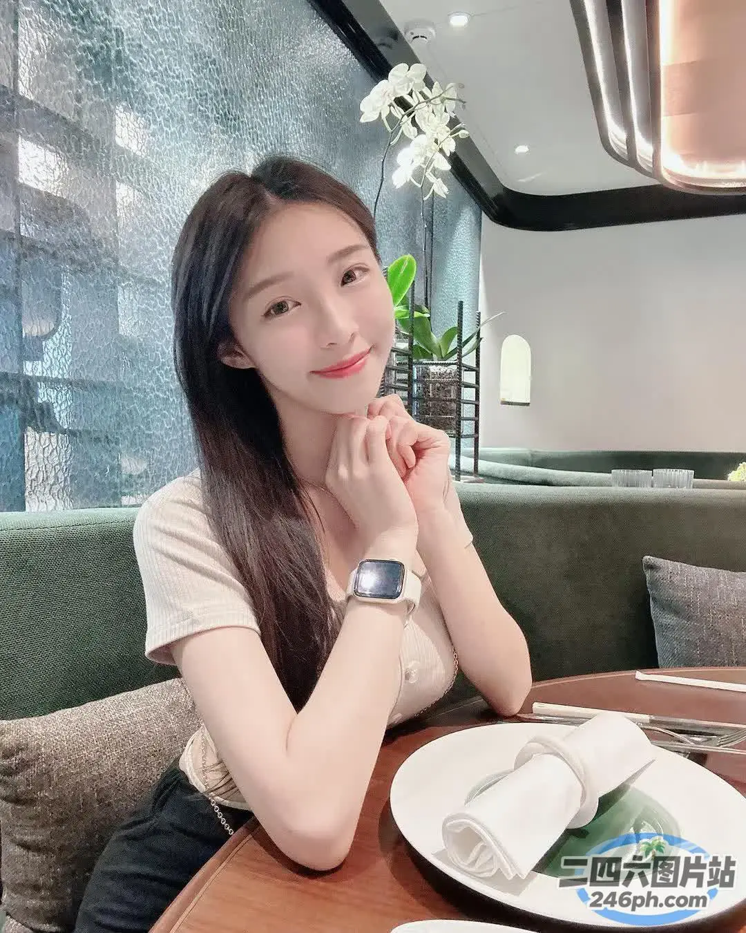 阿拉菲女人坐在桌子旁，手里拿着一盘食物