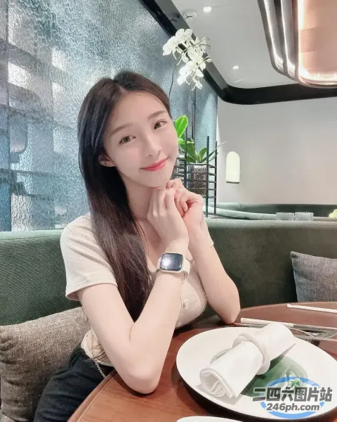 阿拉菲女人坐在桌子旁，手里拿着一盘食物