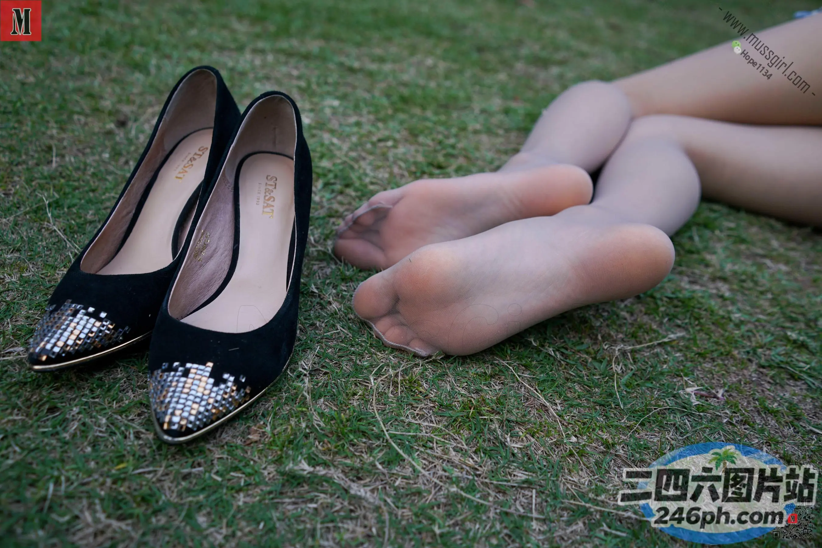 有一个女人躺在草地上，双脚抬起