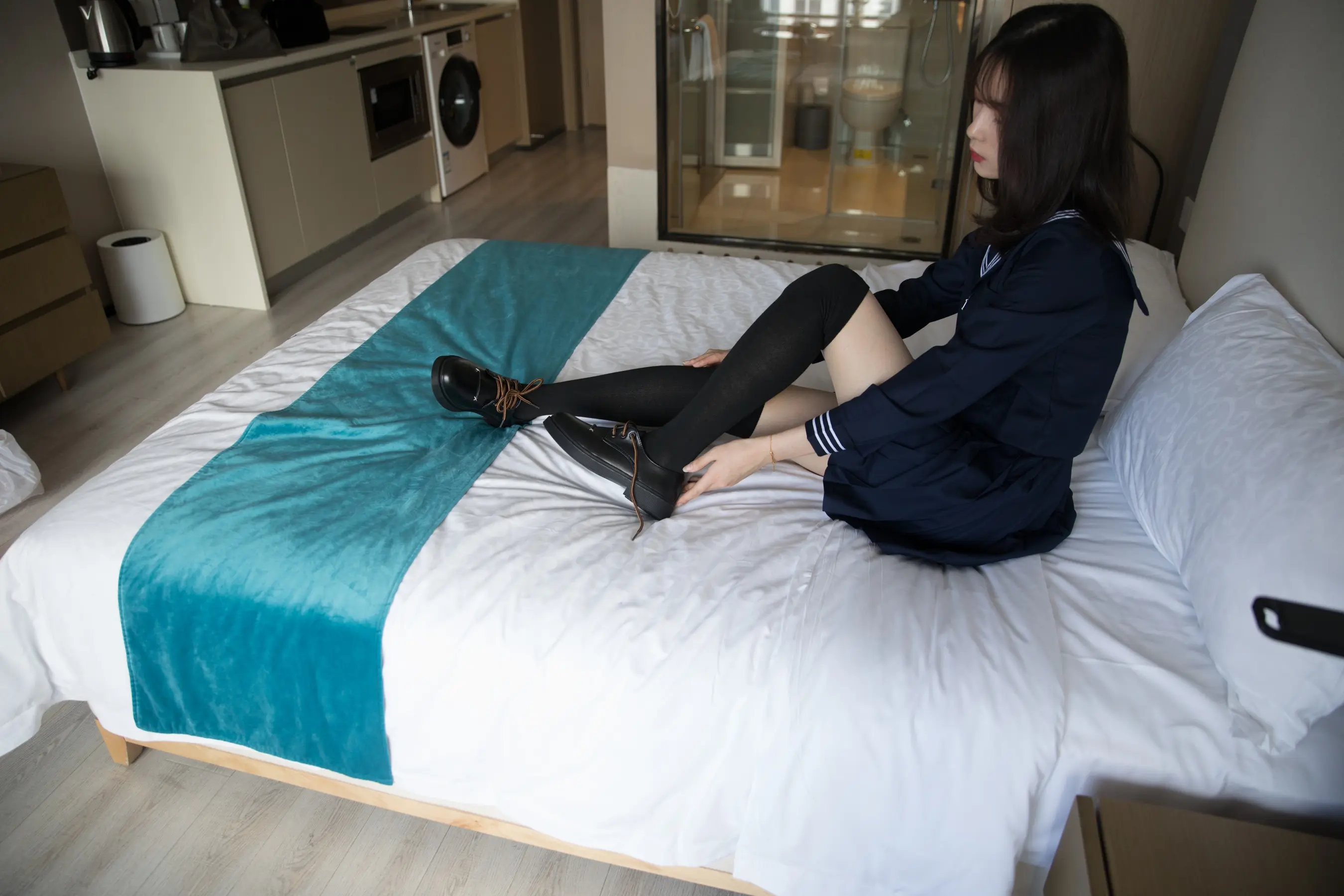 床上躺着一个女人，上面盖着一条蓝色的毯子