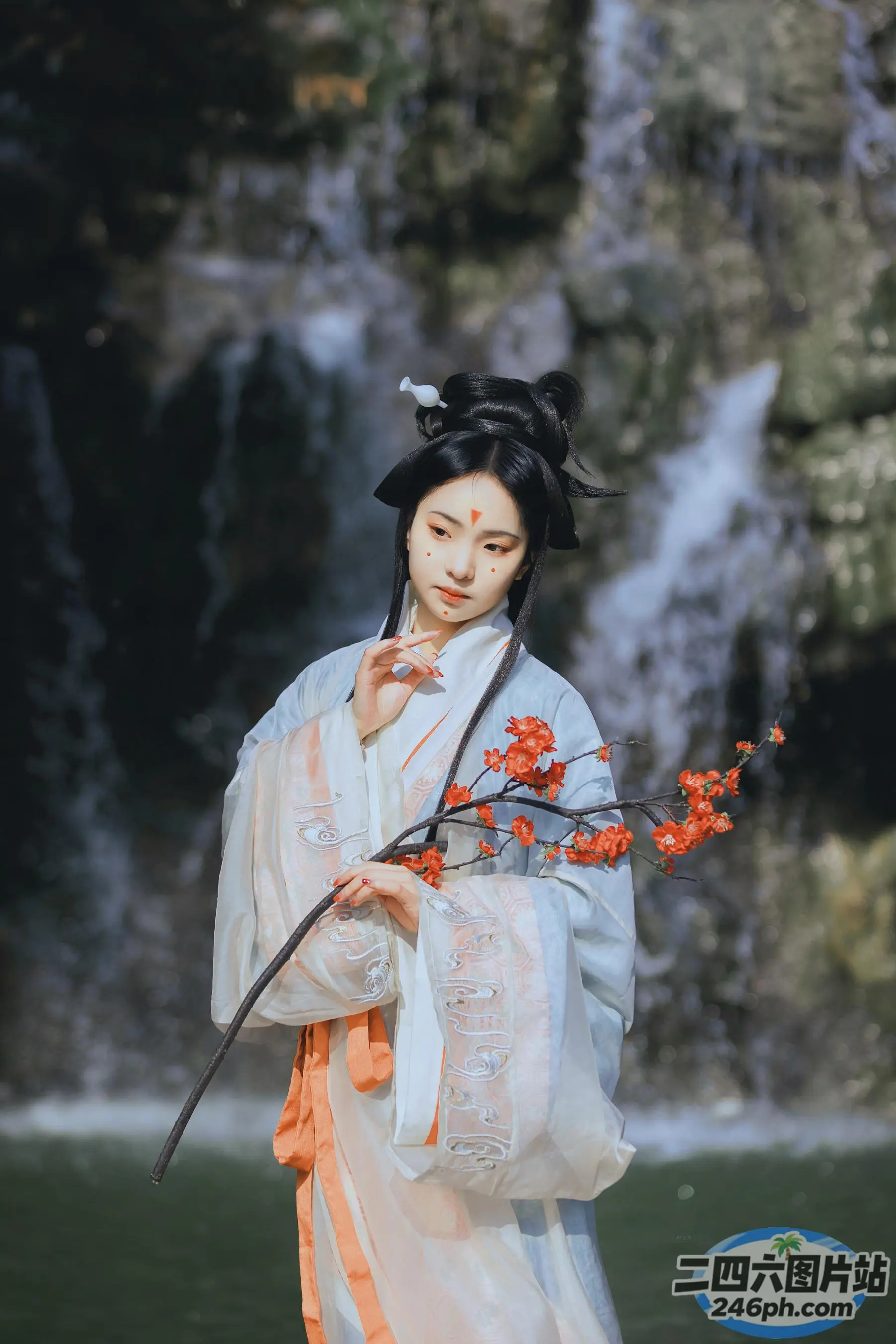穿着白色连衣裙的阿拉夫德女人，手里拿着一根树枝