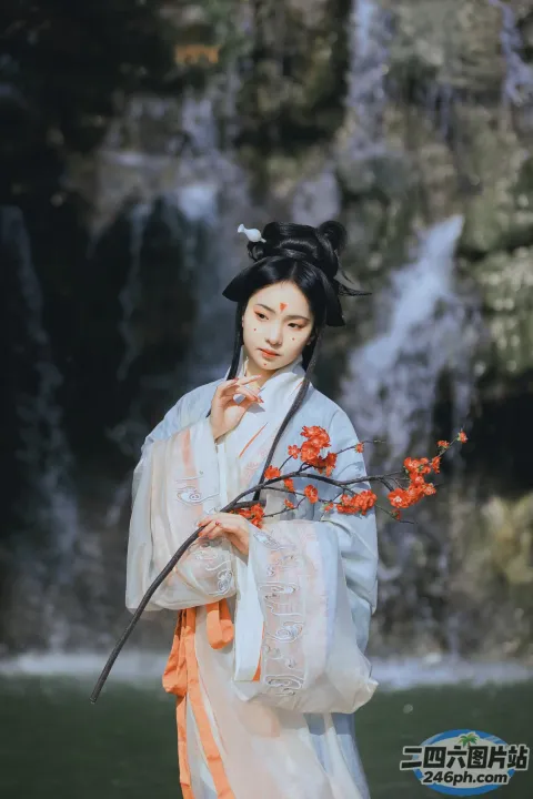 穿着白色连衣裙的阿拉夫德女人，手里拿着一根树枝