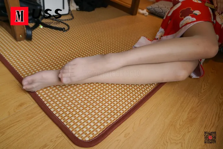 有一个女人盘着双腿坐在垫子上