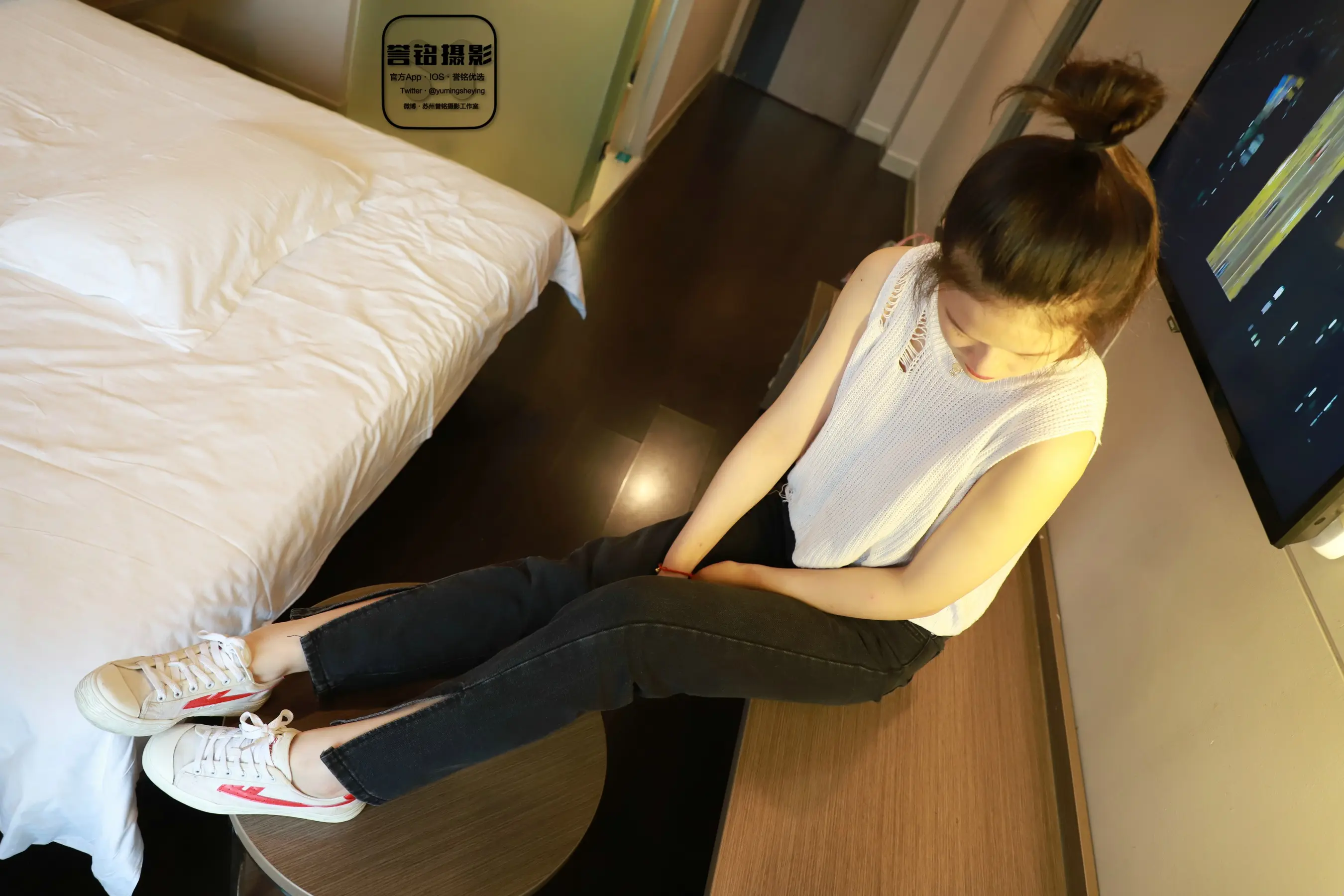 有一个女人坐在床上，双脚抬起