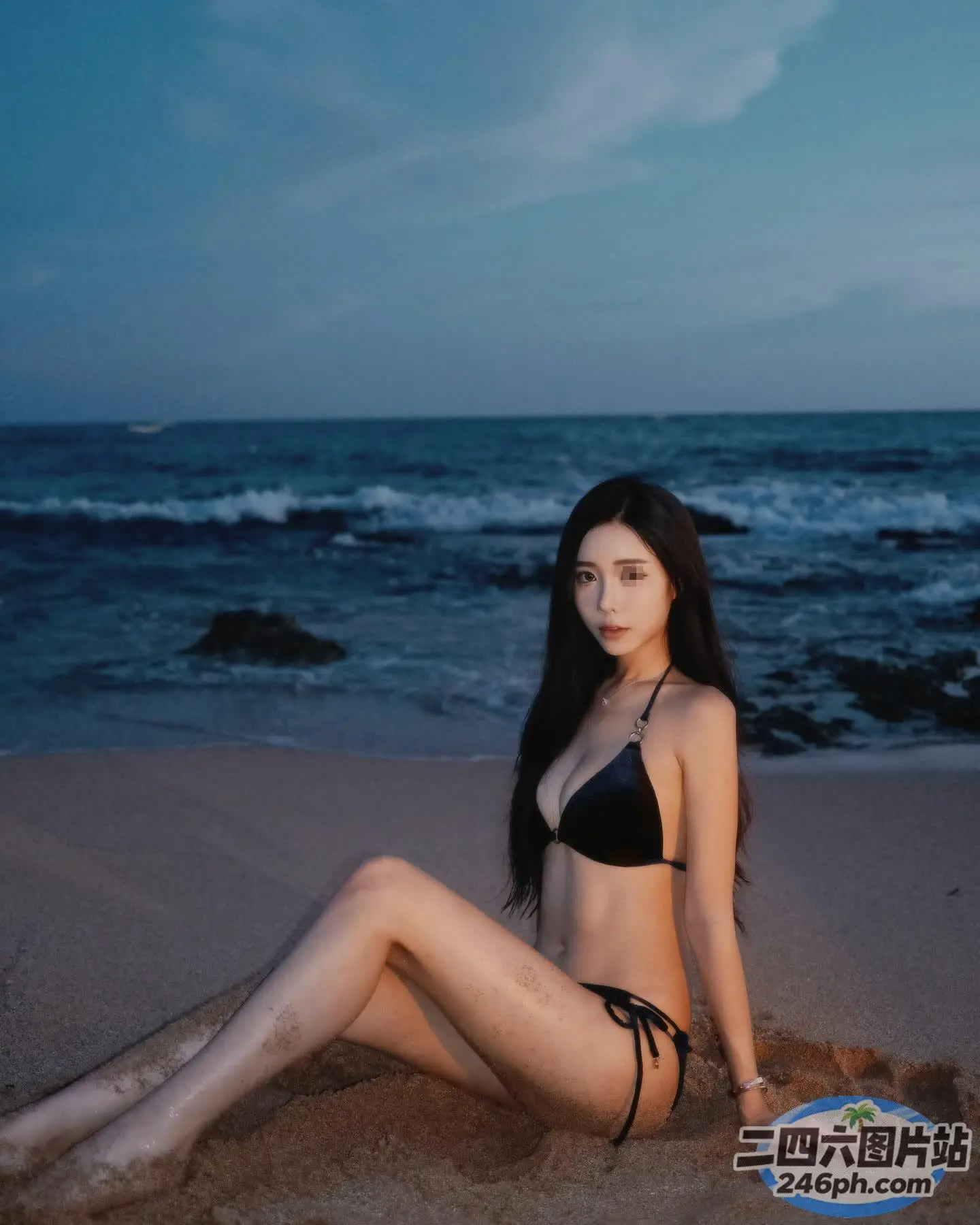 穿着黑色比基尼坐在海滩上的 arafed 女人
