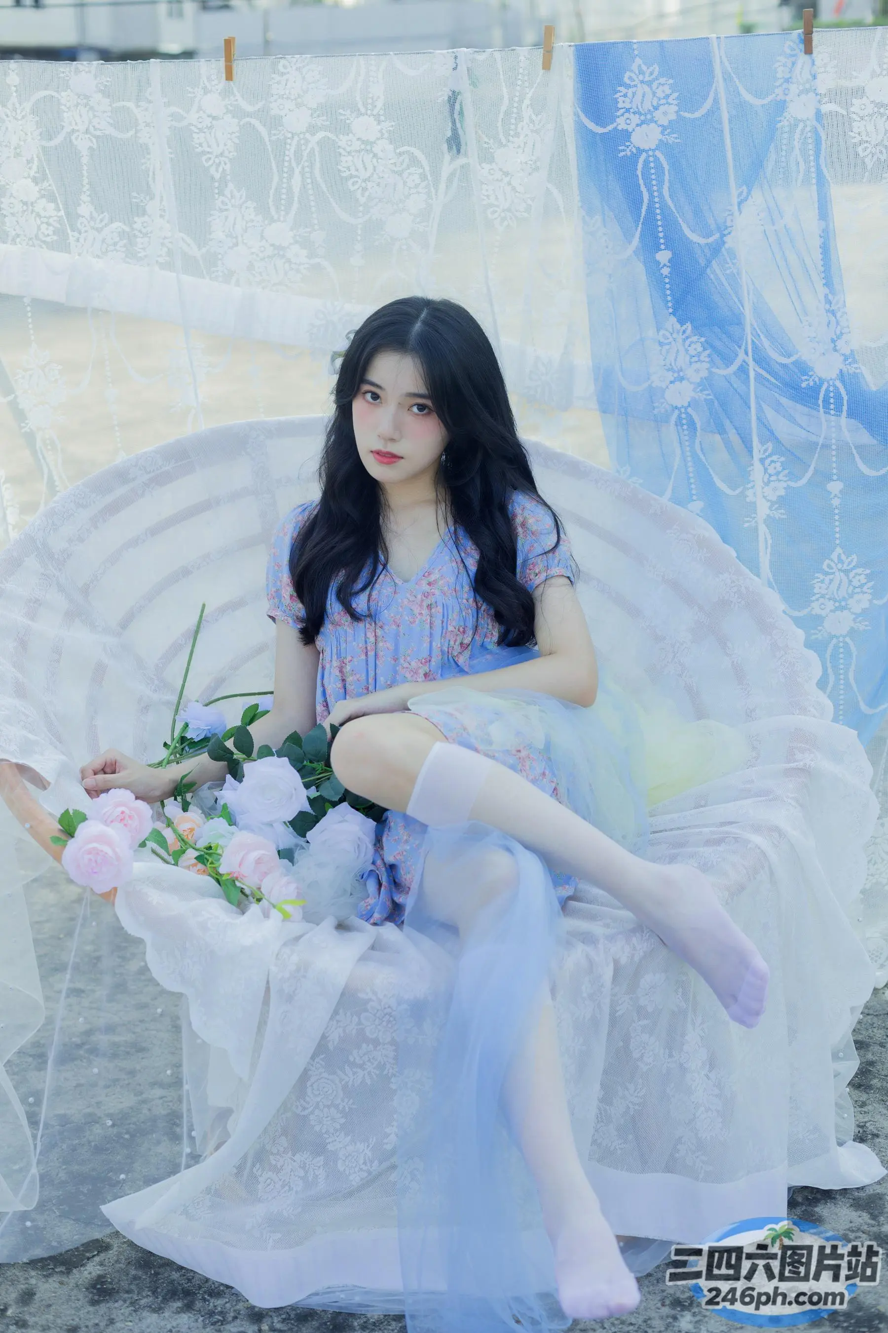有个女人坐在椅子上，手里拿着一朵花