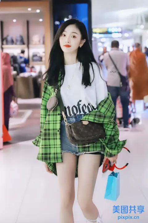 身穿绿色格子衬衫和白色衬衫的 araffe 女孩提着钱包