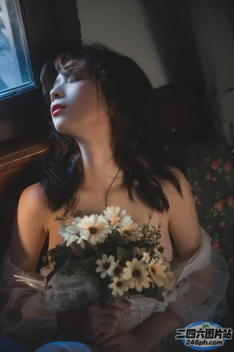 有一位女士坐在沙发上，手里拿着一束鲜花