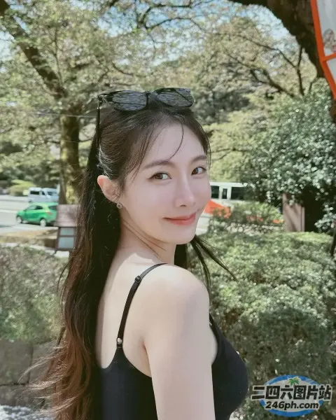 一名身穿黑色连衣裙的女子站在路牌附近的特写