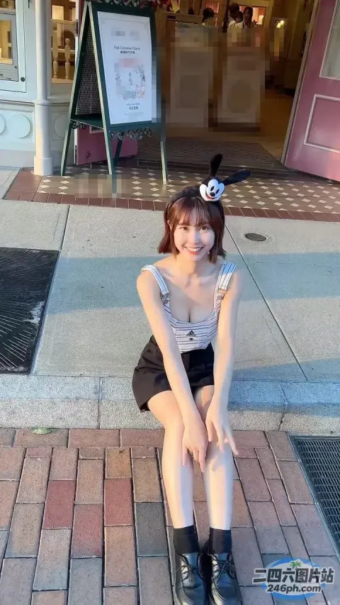 坐在商店前人行道上的阿拉菲女孩