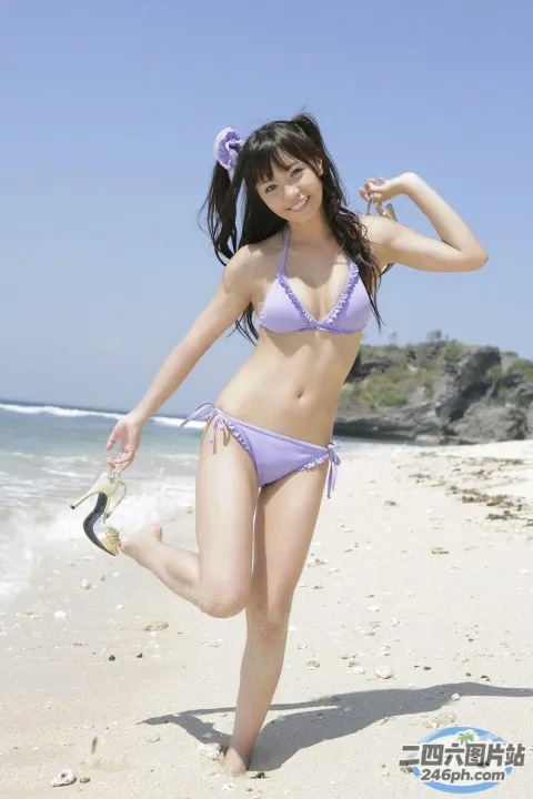 海滩上穿着紫色比基尼的 arafed 亚洲女子