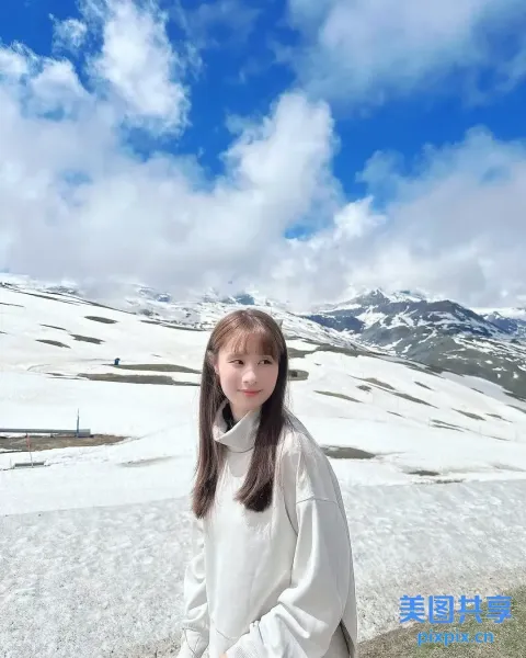 有个女人拿着滑雪板站在雪地里