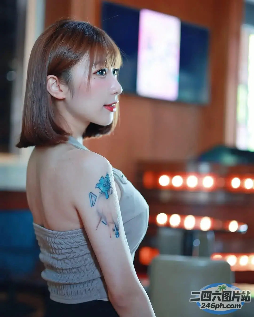 有一个手臂上有纹身的女人，手里拿着一个蛋糕