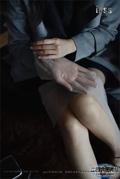 有个女人坐在沙发上，双手放在膝盖上