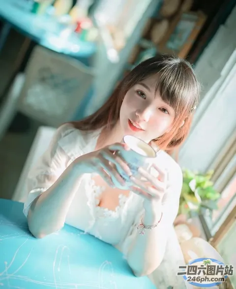 阿拉伯裔亚洲妇女坐在桌子旁，手里拿着一杯茶
