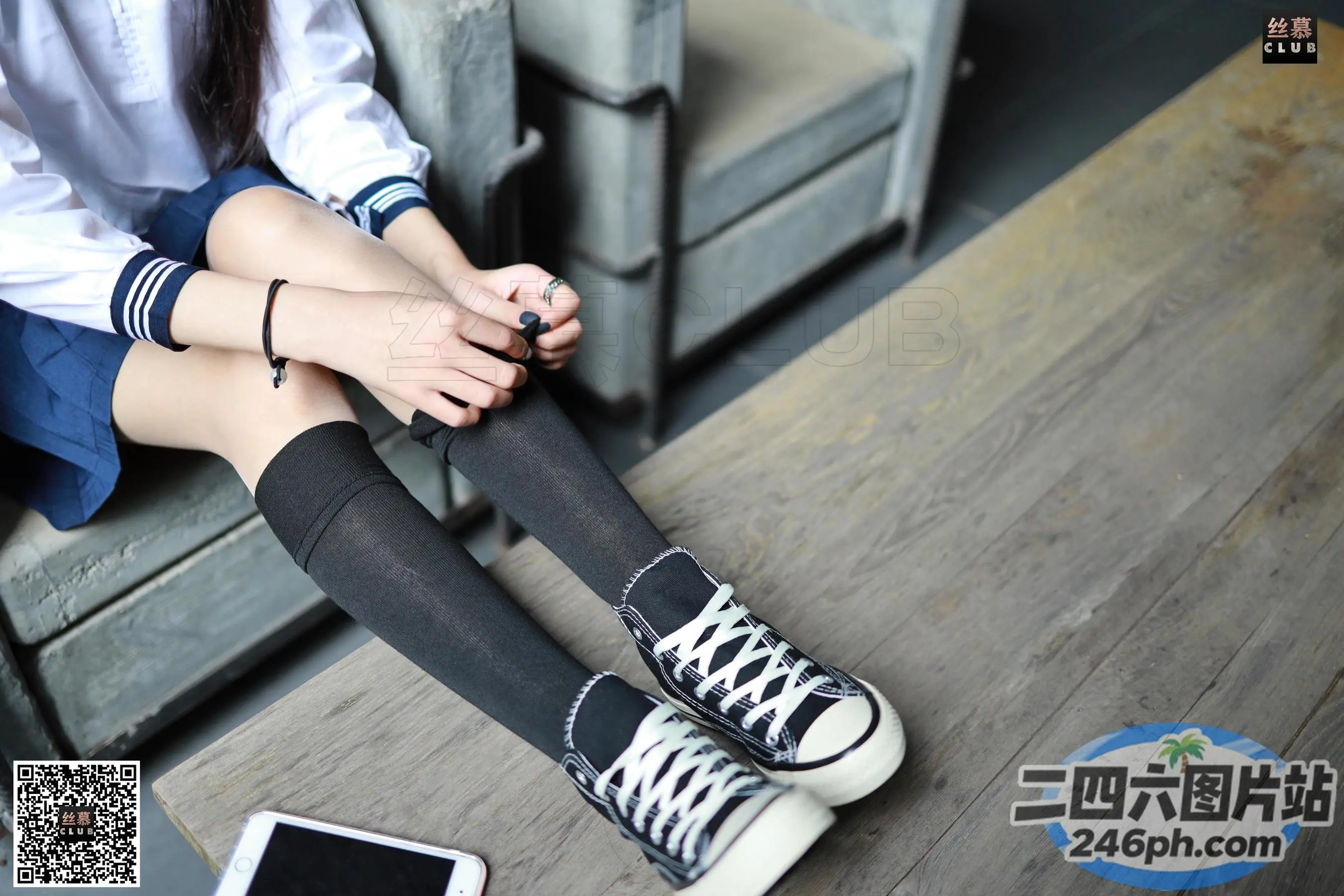 阿拉菲德女人坐在长凳上，双腿交叉，手放在膝盖上
