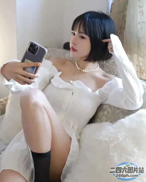 有个女人坐在床上拍自己的照片