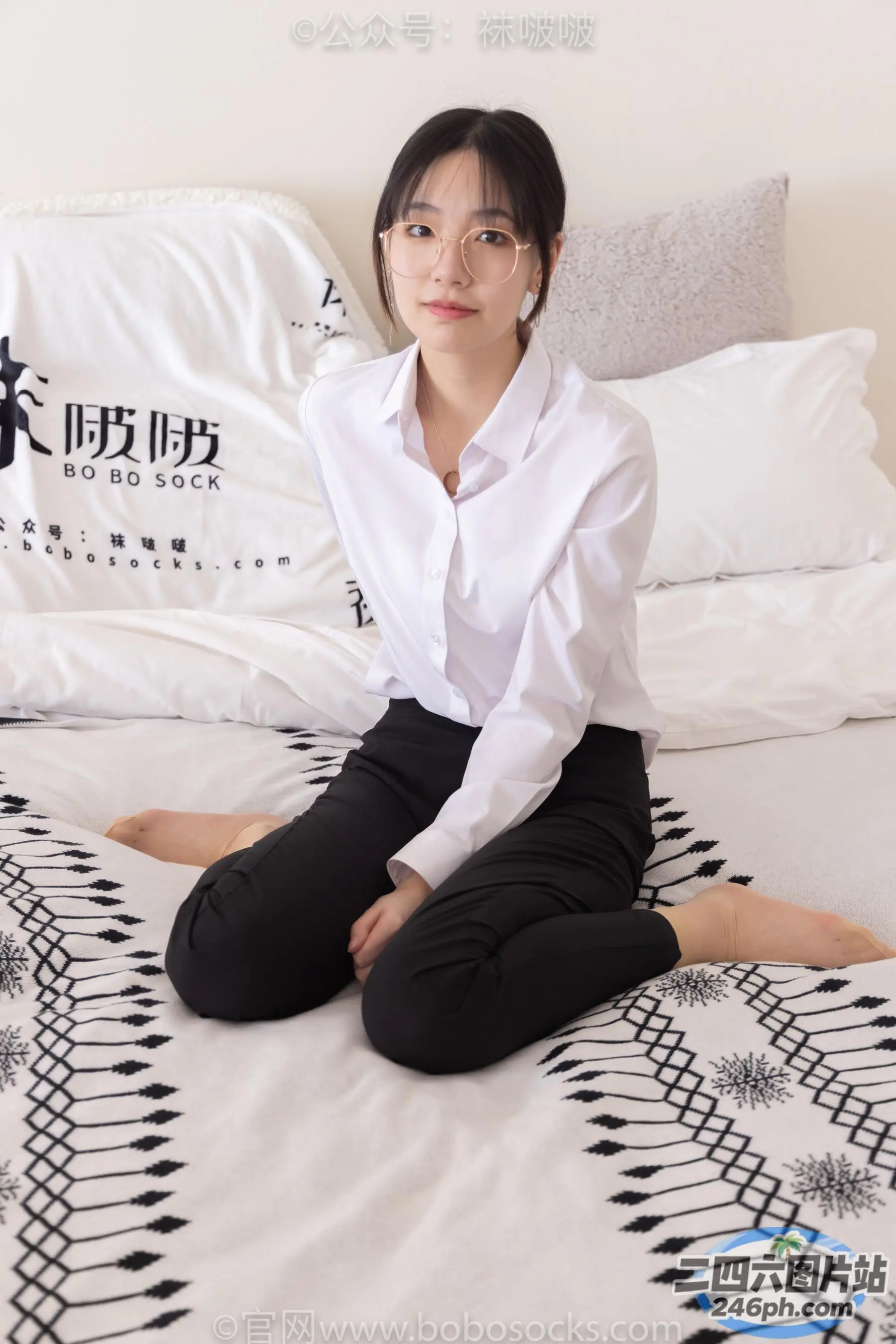 床上坐着一个穿着白衬衫的女人
