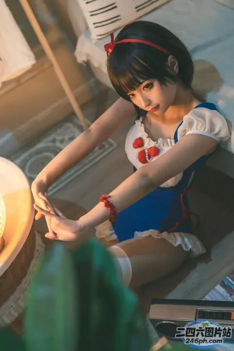 穿着蓝色连衣裙的 Araffe 女孩坐在蛋糕旁边的地板上