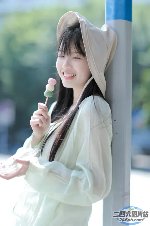 穿着白衬衫、戴着帽子，手里拿着棒棒糖的微笑女人