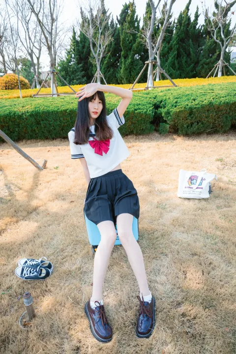 戴着帽子坐在公园秋千上的阿拉夫德女人