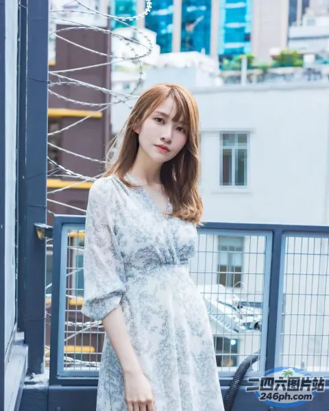 一个穿着白色连衣裙的女人站在阳台上，手里拿着一个手提包