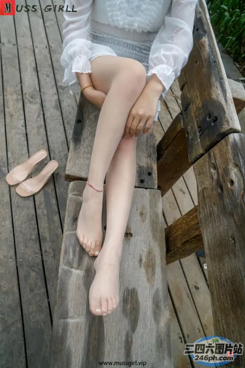 双腿交叉坐在长凳上的阿拉菲德女人