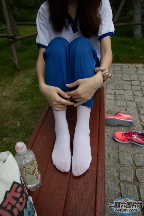 阿拉菲双腿交叉坐在长凳上