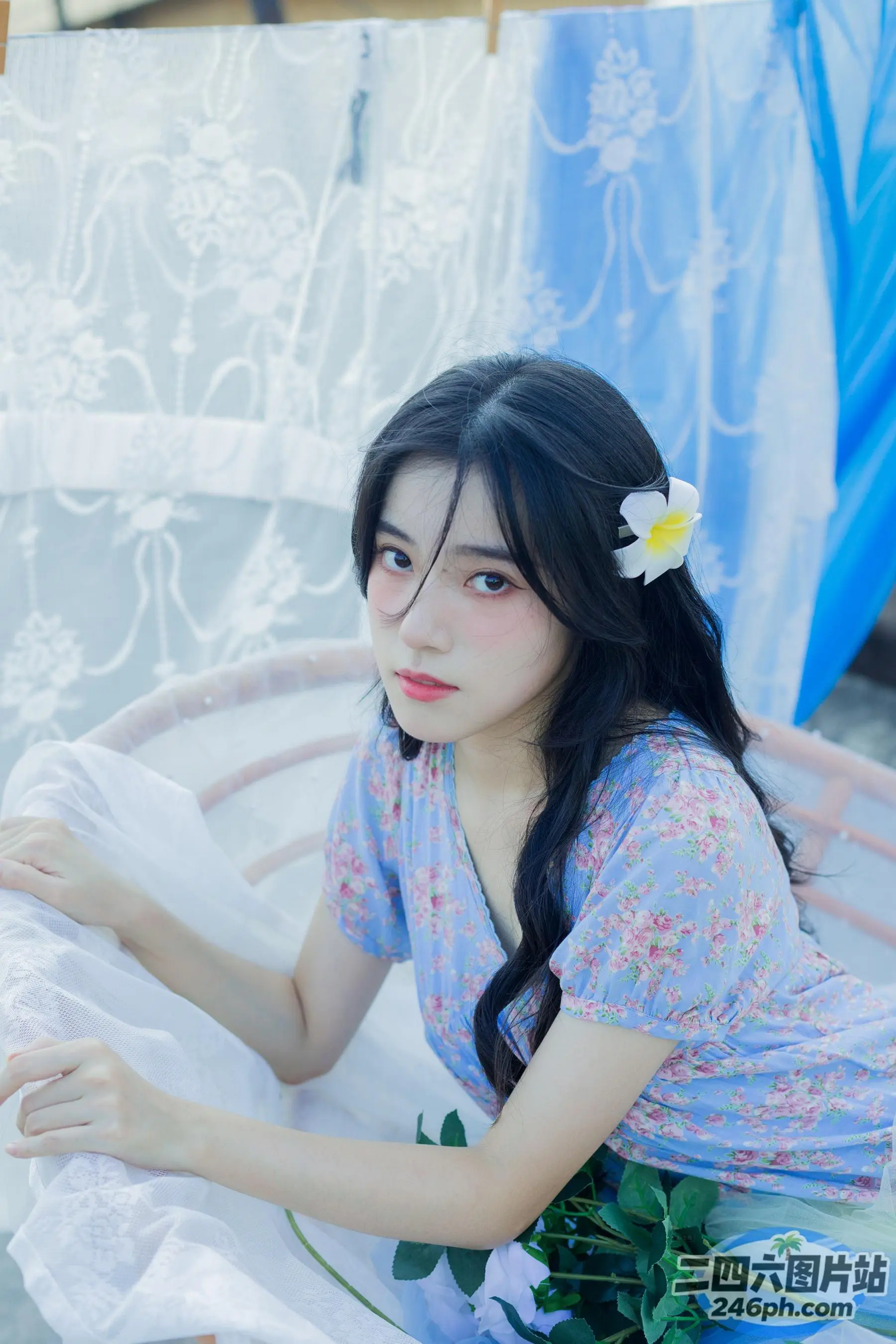 有一个女人坐在床上，头发上插着一朵花