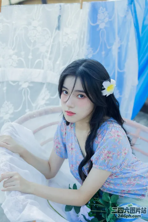 有一个女人坐在床上，头发上插着一朵花