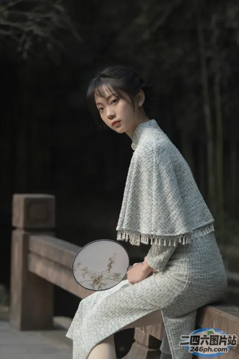 阿拉菲女人坐在长凳上，手里拿着一把扇子和一把扇子