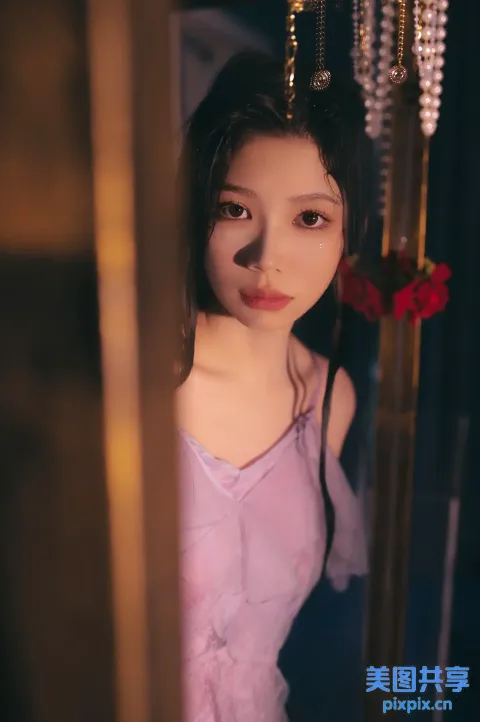 一个穿着粉红色连衣裙的女人站在门前的特写